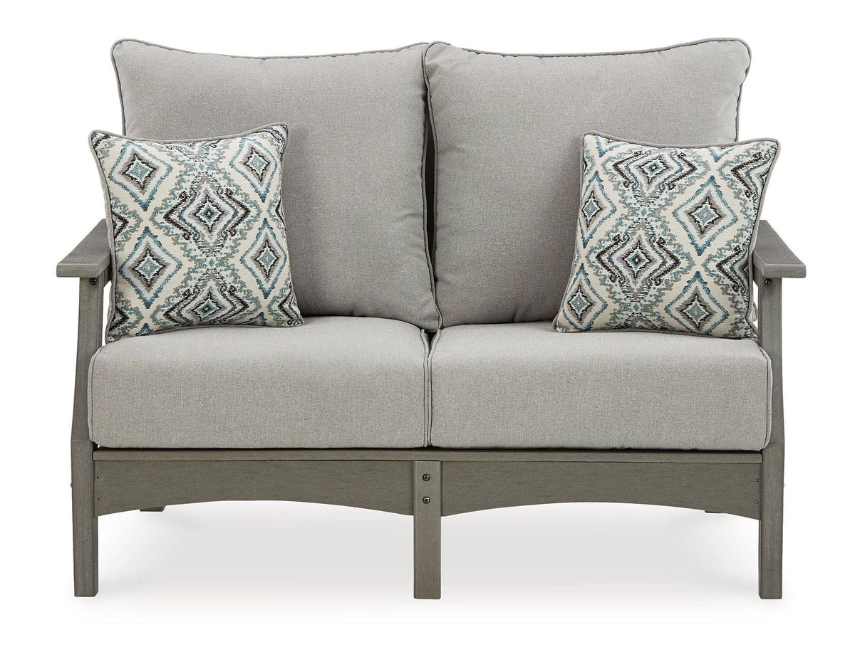 Ashley Furniture Visola outdoor loveseat and matching chairs in a cozy conversation set with cushions and a glass-top table.