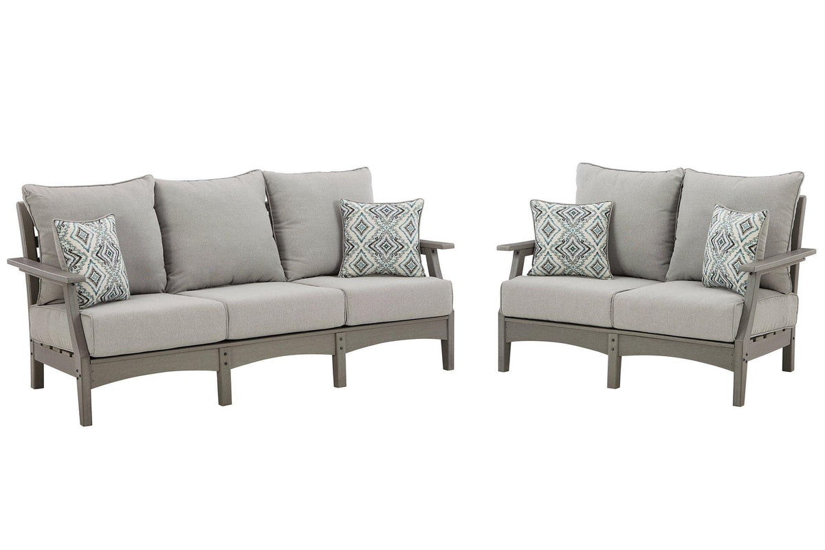 Ashley Furniture Visola outdoor seating set with cushioned chairs and table, perfect for patio or garden relaxation.