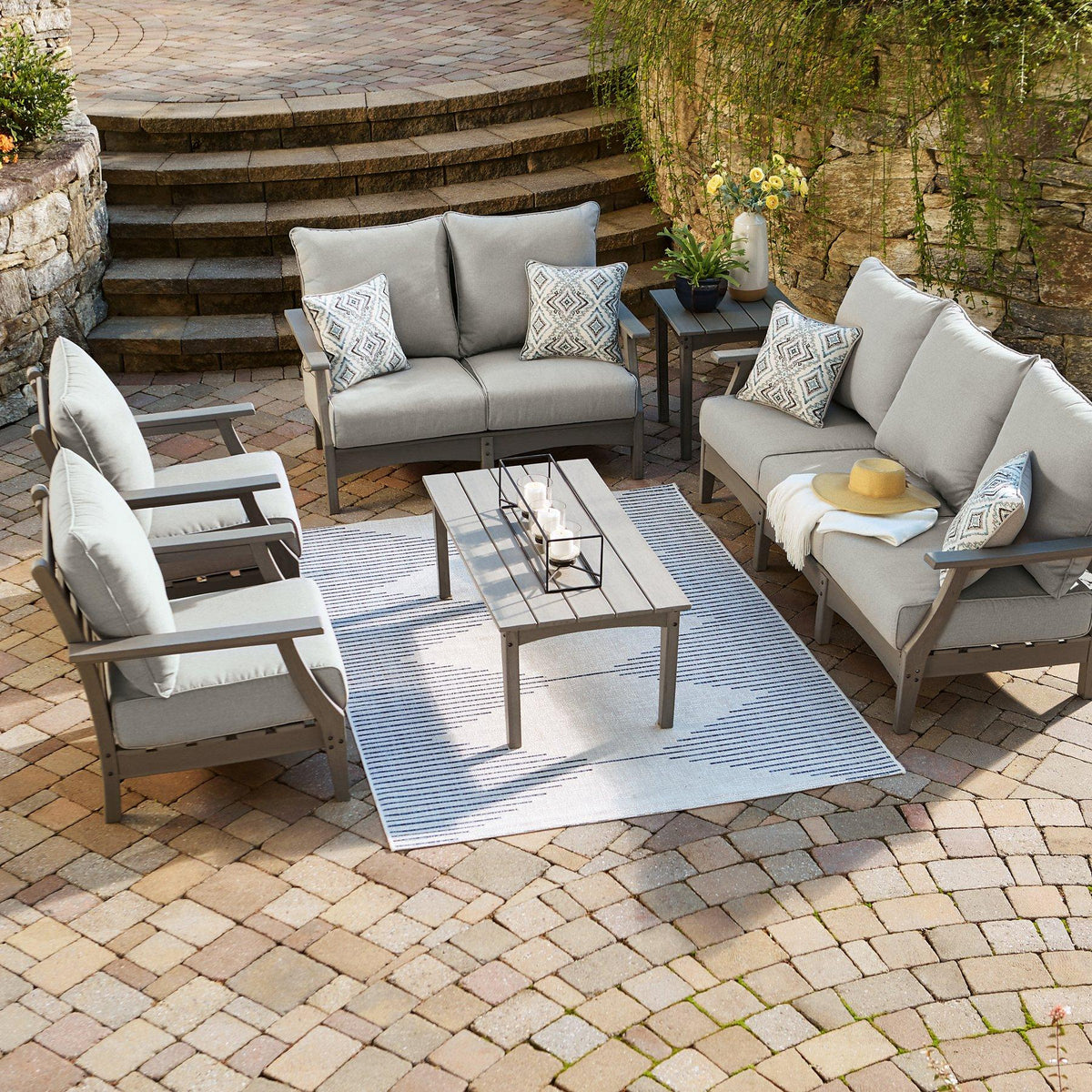 Outdoor table set with sofa and loveseat by Ashley Furniture, featuring cushioned seating and a stylish outdoor table.
