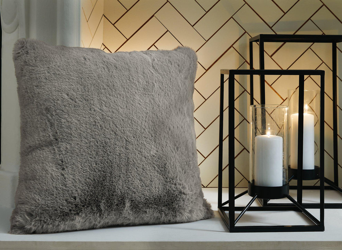 Set of four Ashley Furniture Gariland pillows with soft fabric covers, arranged on a cozy living room sofa.
