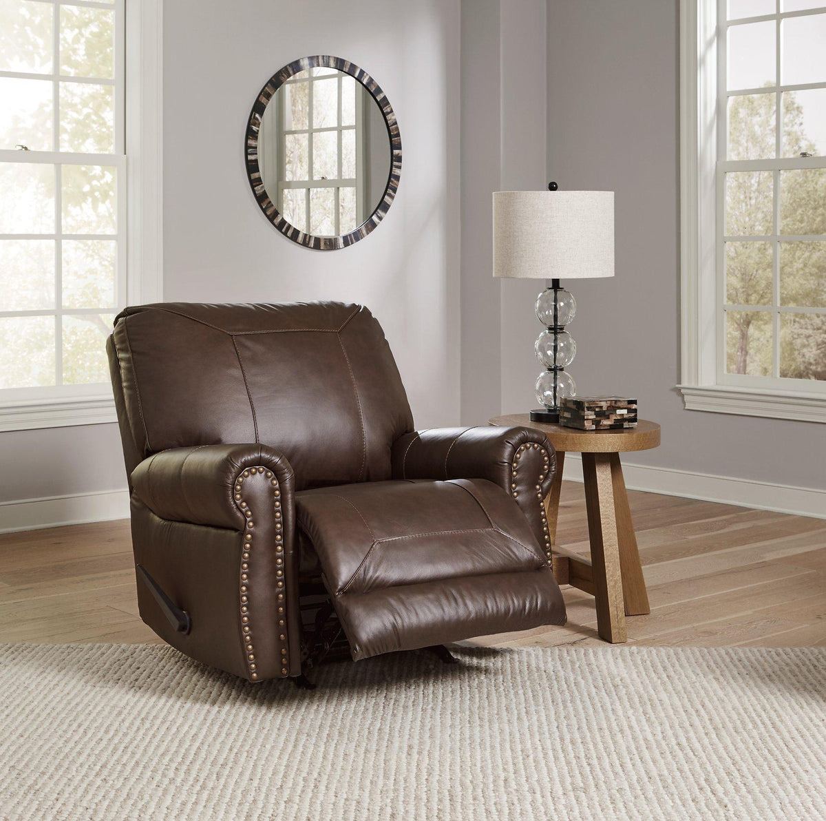 Comfortable Ashley Furniture Colleton recliner with plush cushioning and wood accents, shown in a neutral fabric finish.