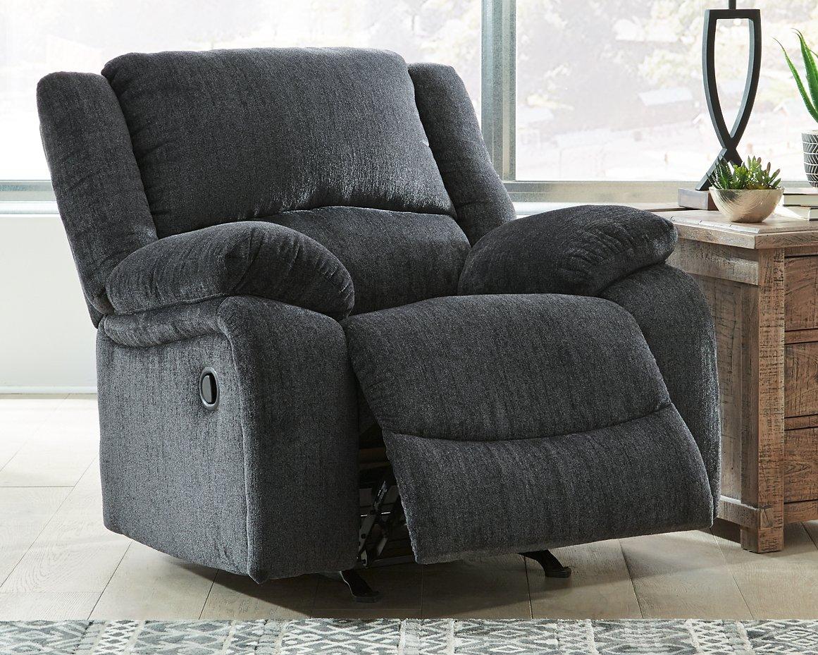 Ashley Furniture Draycoll recliner showing plush fabric, padded armrests, and a comfortable recline in a modern living room setting.