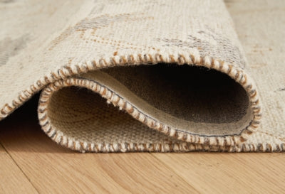 Close-up of Ashley Furniture Calkin Rug showcasing its detailed woven pattern and texture in neutral tones.
