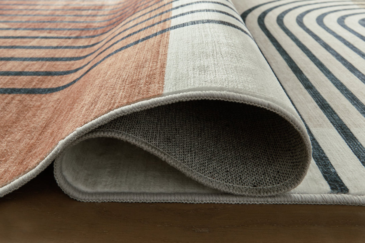 Close-up of Ashley Furniture Farrendale washable area rug with detailed pattern and soft texture in neutral tones.