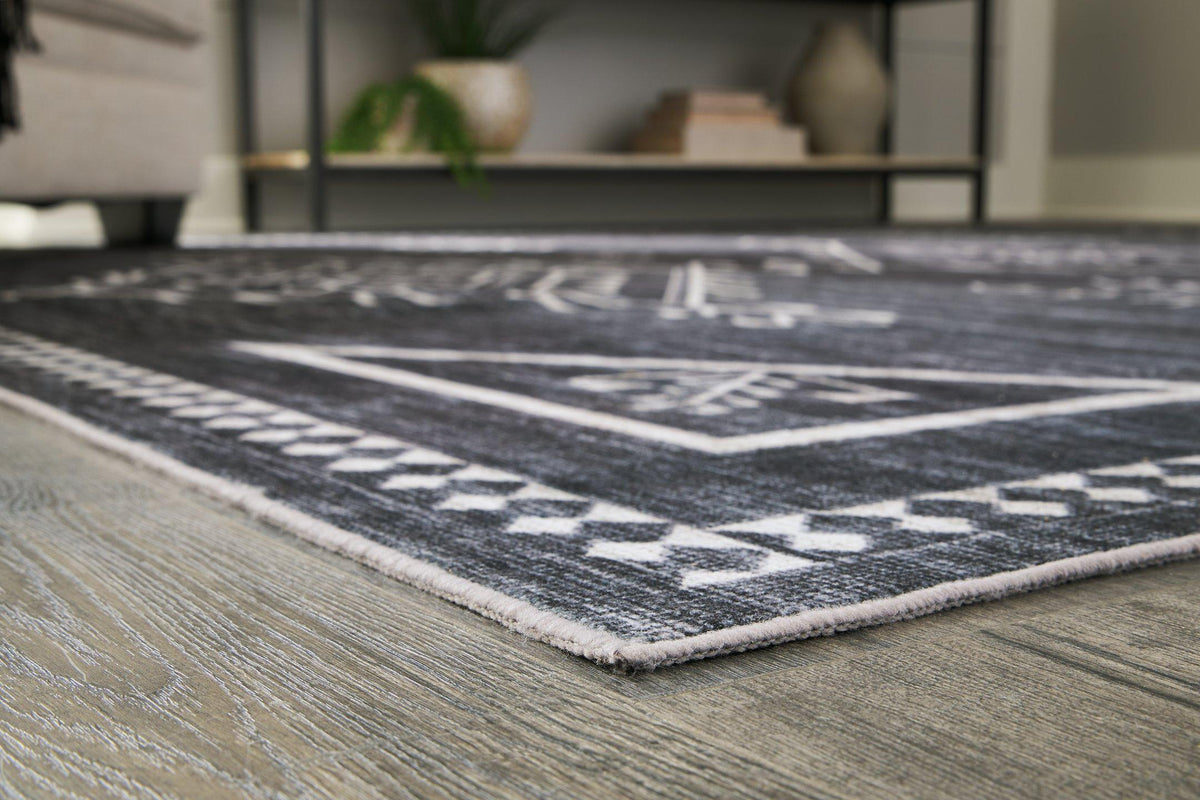 Soft Arloman rug by Ashley Furniture featuring a textured pattern in neutral tones, ideal for living room or bedroom decor.