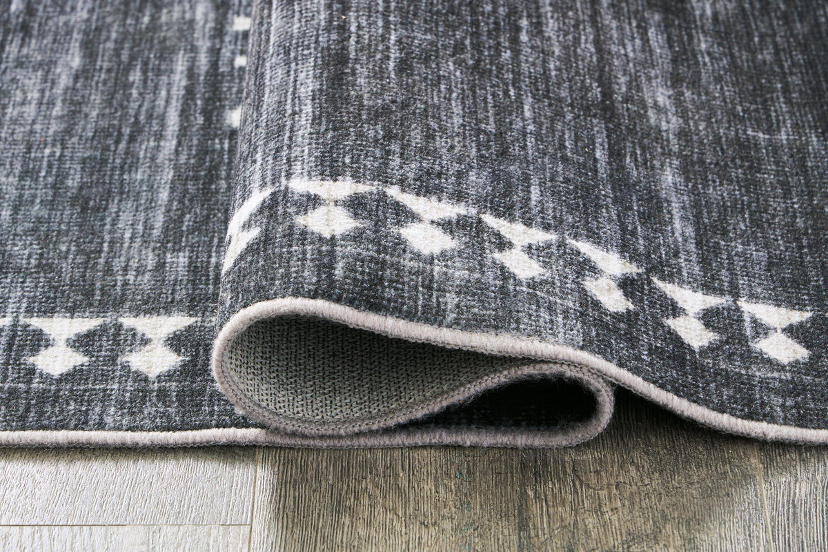 Close-up of the Ashley Furniture Arloman Rug showcasing its textured pattern and warm neutral tones.