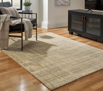 Ashley Furniture Janston Rug featuring a plush, patterned design in neutral tones, perfect for adding warmth to any living space.