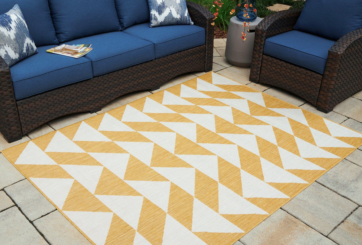 Ashley Furniture Thomley 5' x 7' rug with a soft, patterned design suitable for living rooms or bedrooms.
