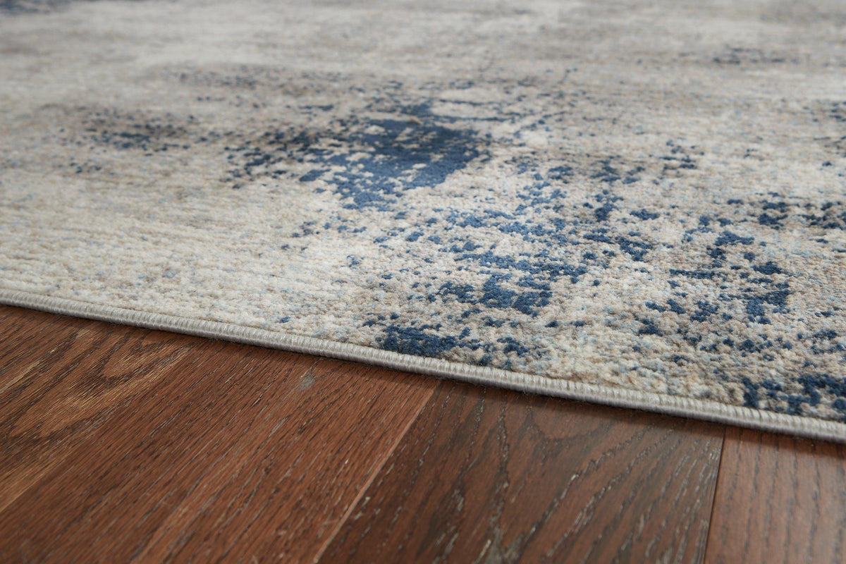 Ashley Furniture Wrenstow 5'3" x 7'3" rug featuring a detailed pattern in neutral tones, ideal for living room or bedroom decor.