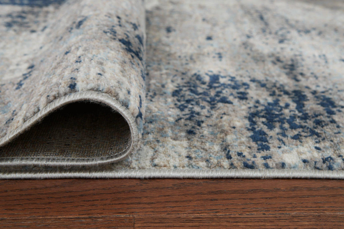 Ashley Furniture Wrenstow 5'3" x 7'3" rug with intricate pattern and soft texture, ideal for living room or bedroom decor.