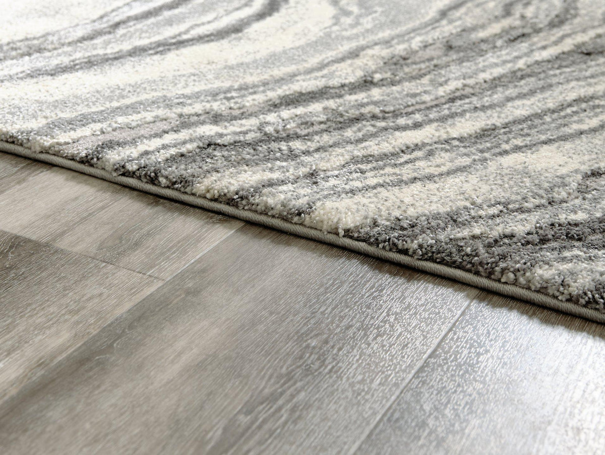 Ashley Furniture Wysdale 7'10" x 10'3" rug with intricate patterns and warm tones, showcasing a soft, plush surface.
