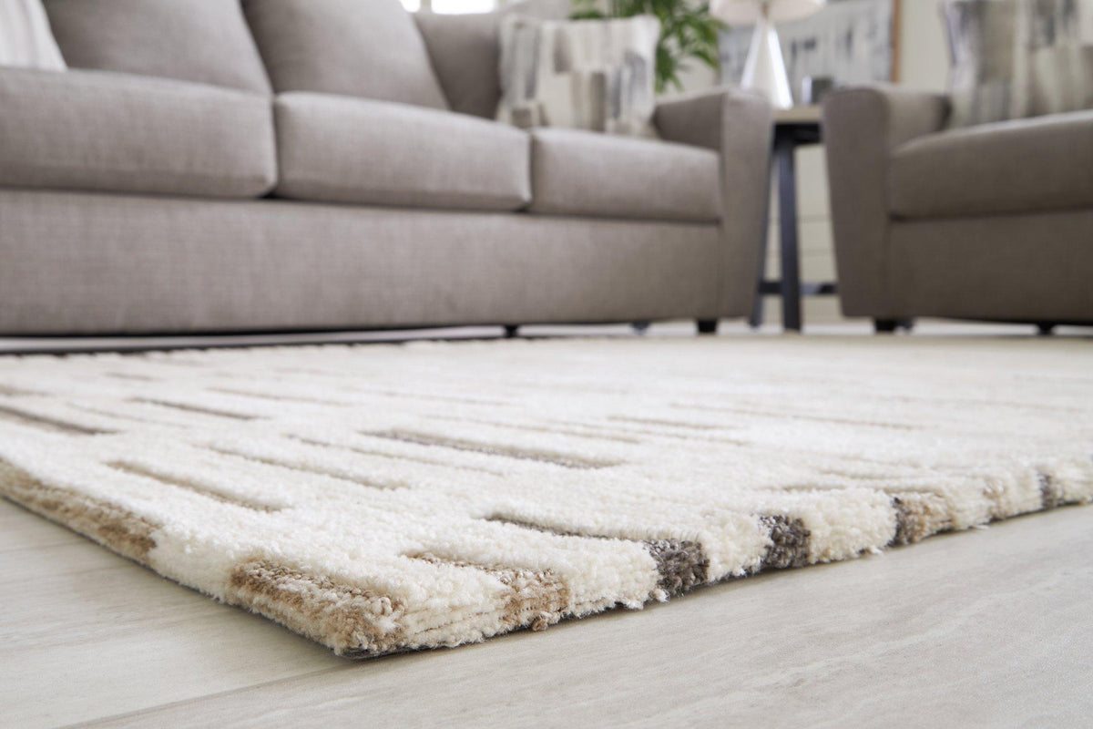Large Leesdale 8x10 rug by Ashley Furniture featuring a detailed, woven pattern in neutral tones for living room decor.
