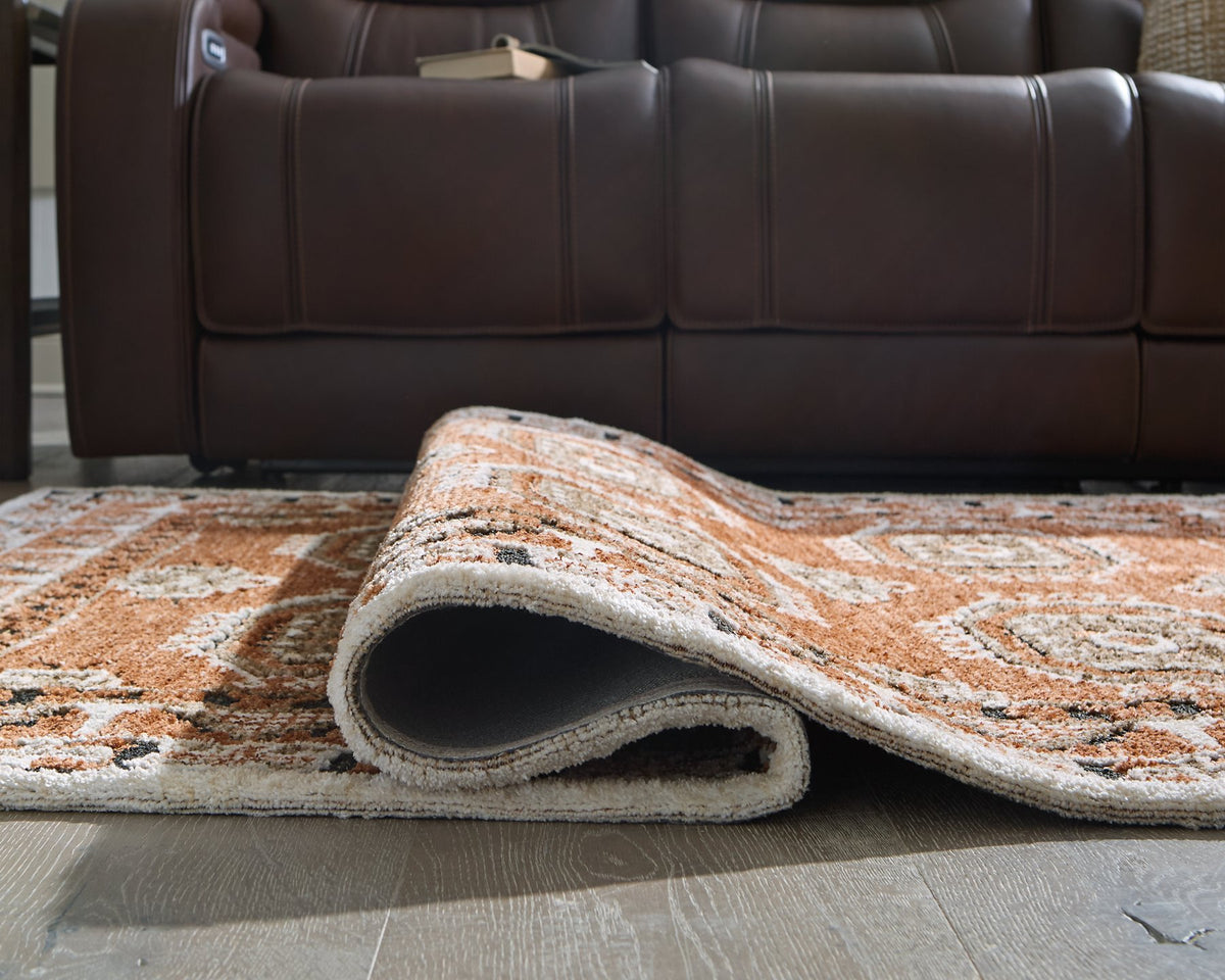 Medium Ashley Furniture Qaabiz Area Rug with intricate patterns, detailed close-up view showing texture and design.