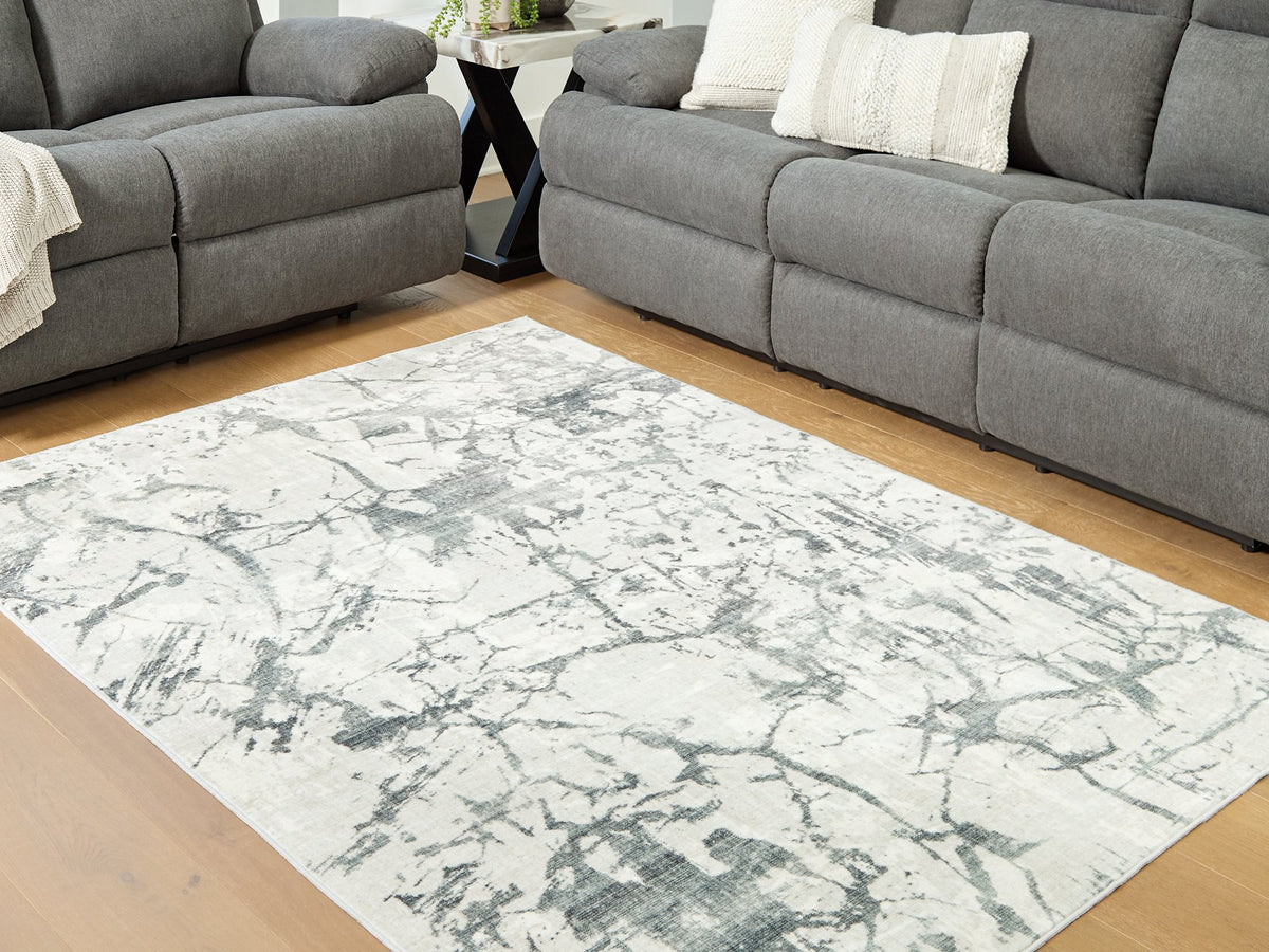 Medium Ashley Furniture Tobinbury washable area rug with a textured pattern in neutral tones, suitable for living rooms or bedrooms.