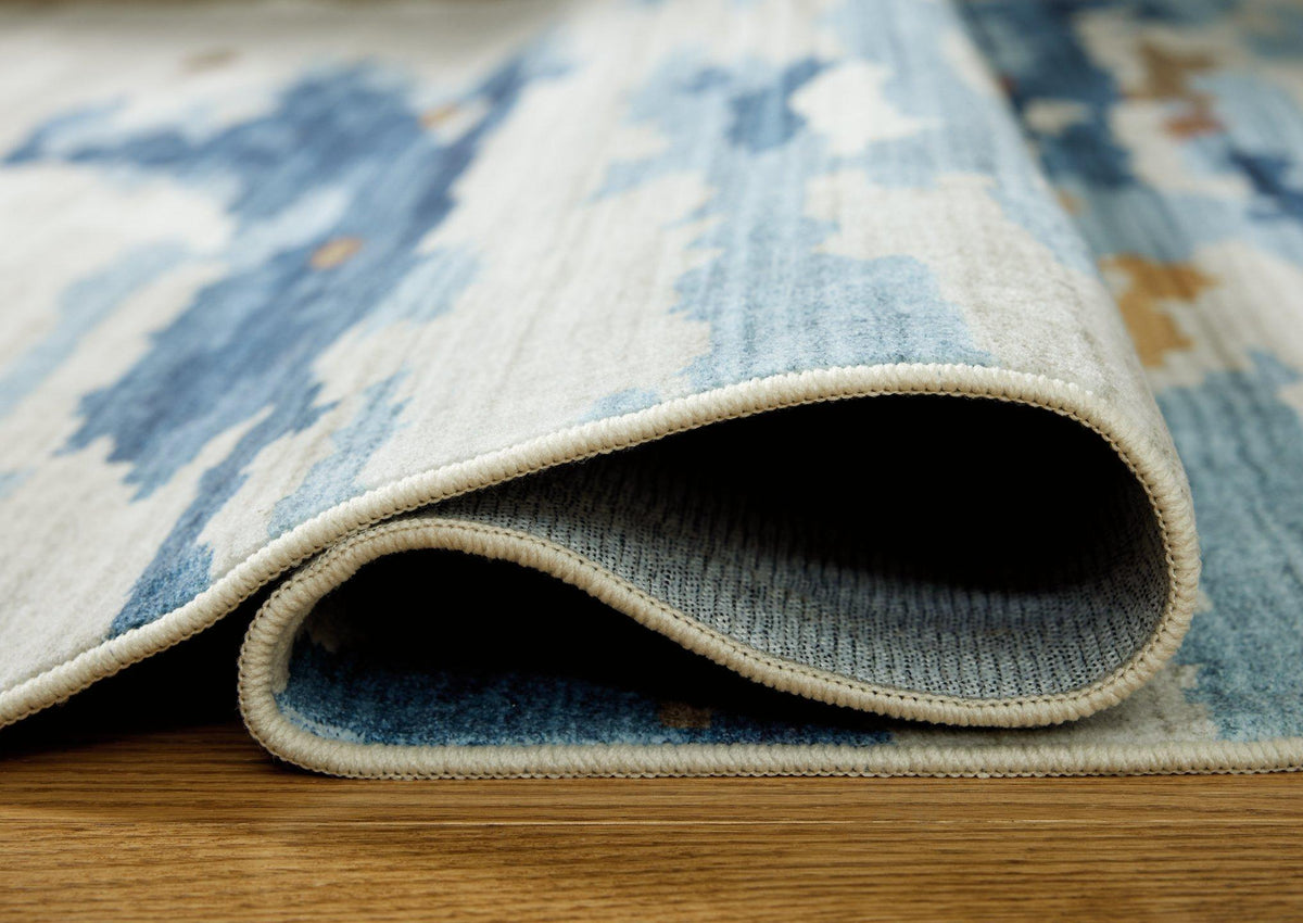 Medium washable rug from Ashley Furniture with a soft, patterned design featuring neutral tones for versatile home decor.