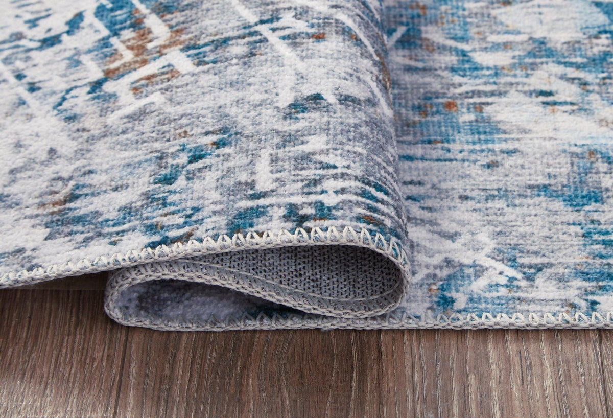 Medium Ashley Furniture washable rug, 5' x 7', with a soft, patterned design suitable for living rooms or bedrooms.