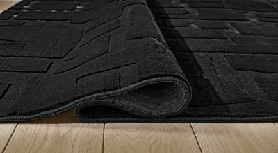 Medium-sized Ashley Furniture Gibbswell washable 5' x 7' area rug with detailed pattern and soft texture on a neutral background.