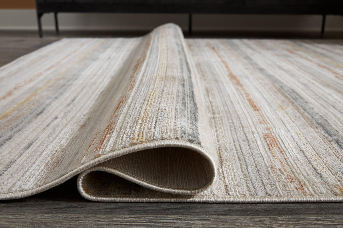 Medium Ashley Furniture Artney Rug with intricate patterns and soft textures, ideal for living room or bedroom decor.
