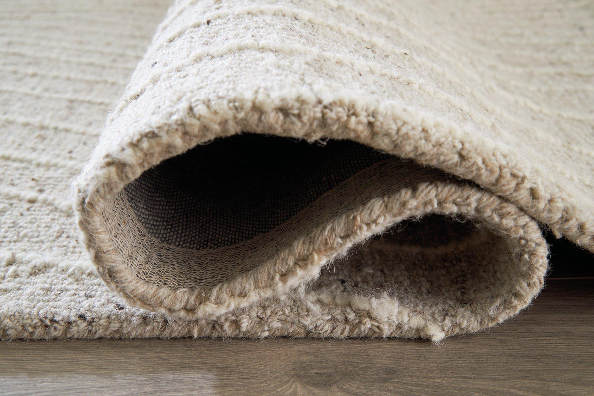 Medium Ashley Furniture Varahill rug featuring a textured, patterned design in neutral tones for living room or bedroom decor.