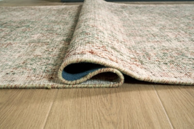 Close-up of Ashley Furniture Rossbury Rug showing intricate woven pattern and soft texture in neutral tones.