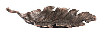 Avermund sculpture by Ashley Furniture, modern metal artwork with intricate detailing, placed on a wooden surface.