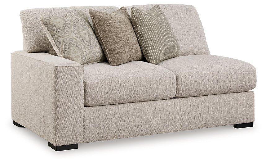 Ashley Furniture Ballyton sectional sofa with plush cushions and neutral fabric, shown in a spacious living room setting.