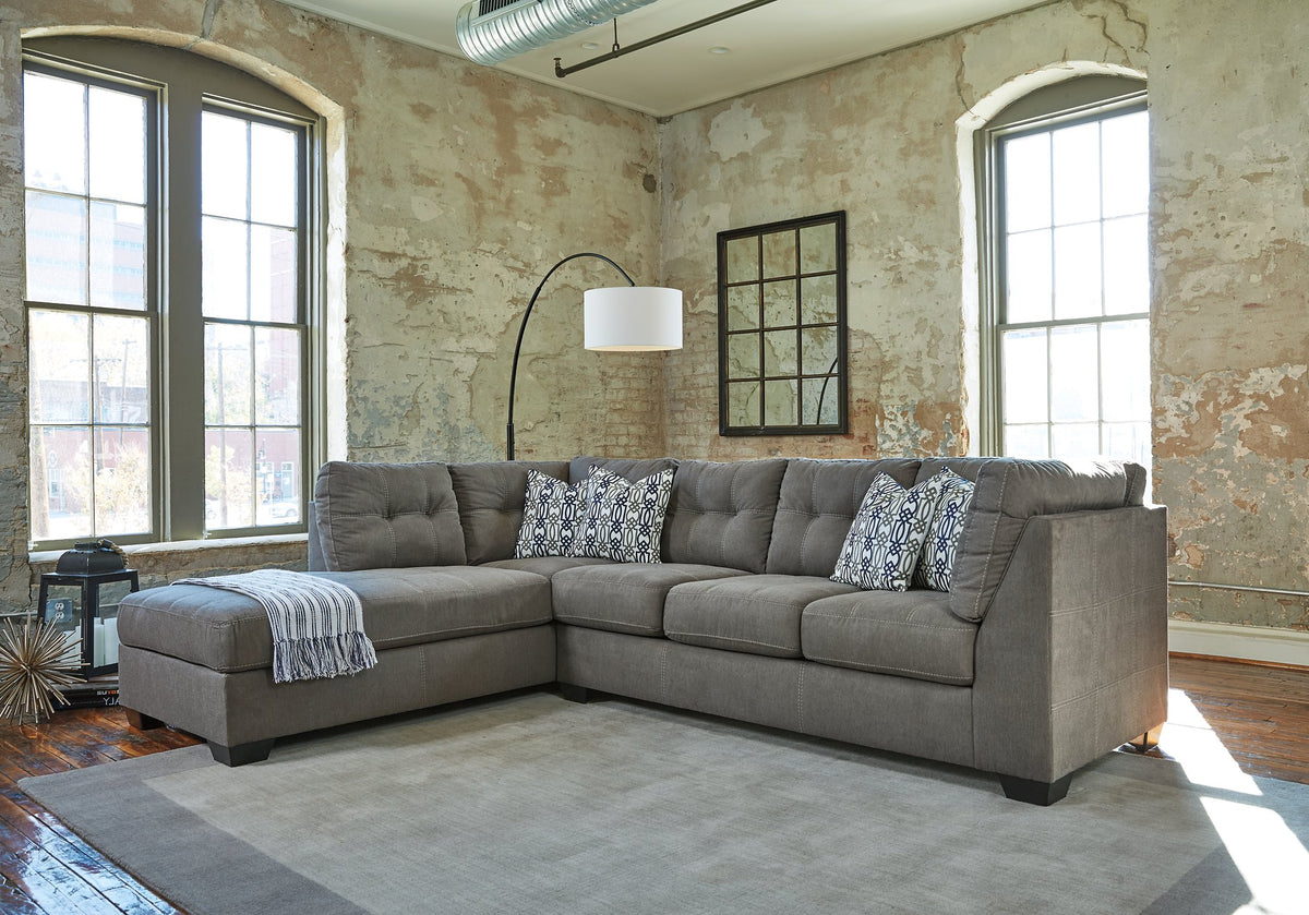 Ashley Furniture Pitkin 2-piece sectional with chaise, showing plush fabric upholstery and modern design in a spacious living room setting.
