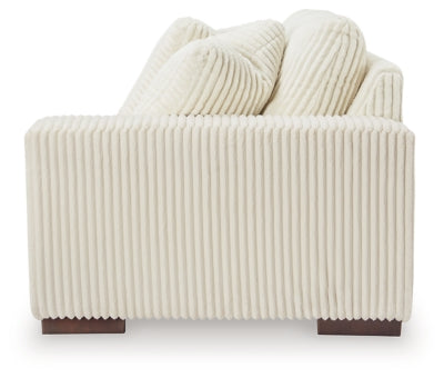 Ashley Furniture Lindyn sectional with chaise showing a modern fabric sofa with cushions and a side view in a living room setting.