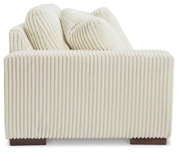 Ashley Furniture Lindyn sectional sofa with plush cushions and modern design, shown in a spacious living room setting.