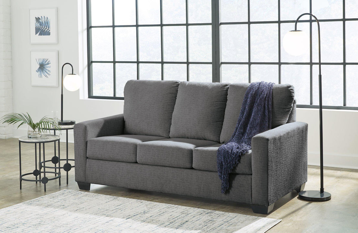 Ashley Furniture Rannis Sleeper Sofa shown in a stylish living room setting, featuring a modern design with plush cushions and fabric upholstery.