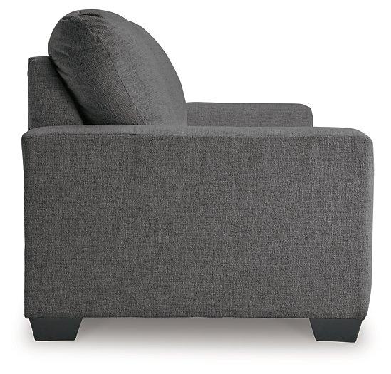 Ashley Furniture Rannis sofa sleeper with plump cushions and neutral fabric, designed for comfortable sitting and sleeping.