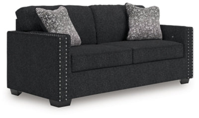 Ashley Furniture Jasmine Peaks sofa with plush beige upholstery and modern design, shown from an angled view.