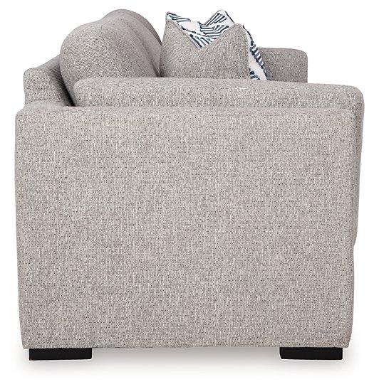 Ashley Furniture Evansley sofa in a neutral fabric with plush cushions and wide armrests, shown in a modern living room setting.