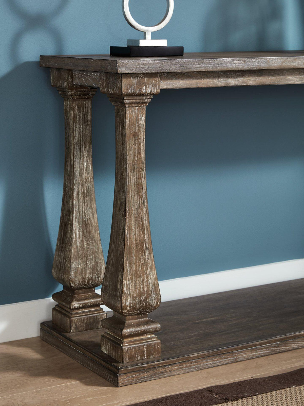 Ashley Furniture Johnelle sofa table with a sleek wooden surface and sturdy legs, ideal for living room decor.