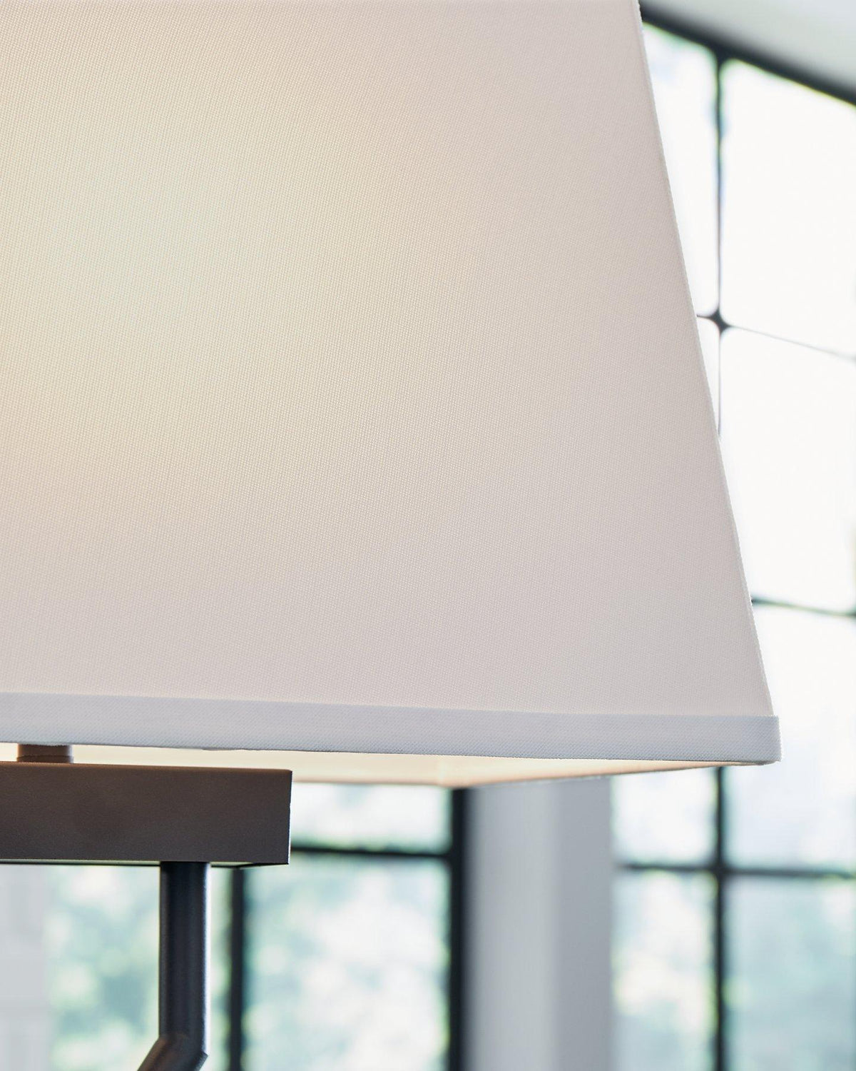 Pair of Ashley Furniture Brookthrone table lamps with beige fabric shades and dark wood bases, set on a wooden table.
