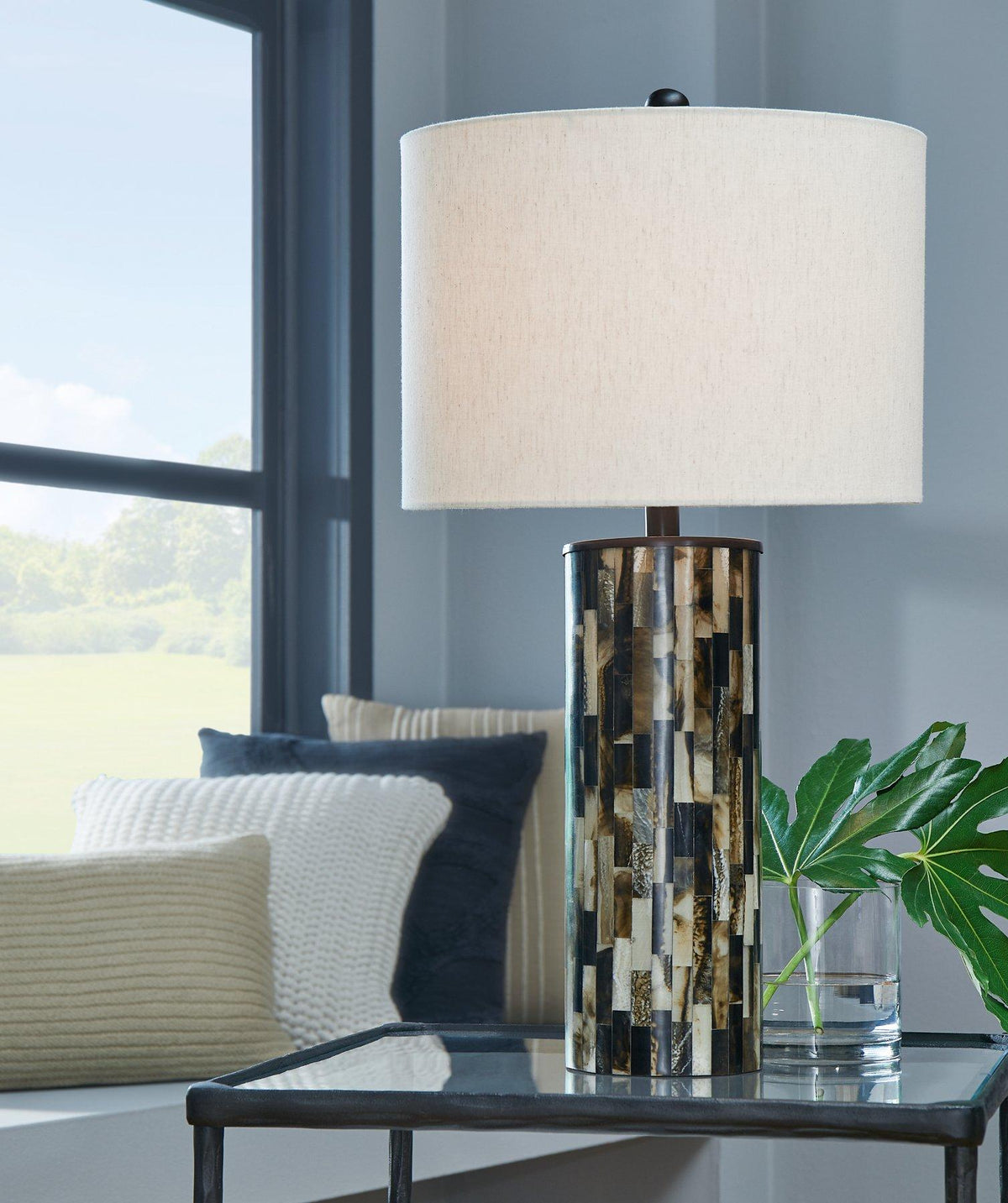 Ellford table lamp by Ashley Furniture with a modern design, featuring a sleek base and a fabric lampshade for stylish lighting.