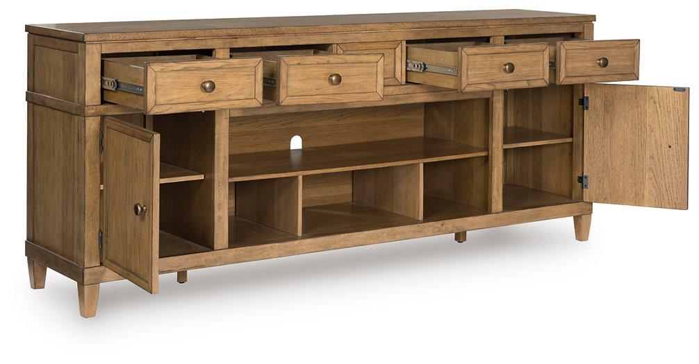 Ashley Furniture Sharlance 81-inch TV stand with open shelves and storage compartments in a modern wood finish.
