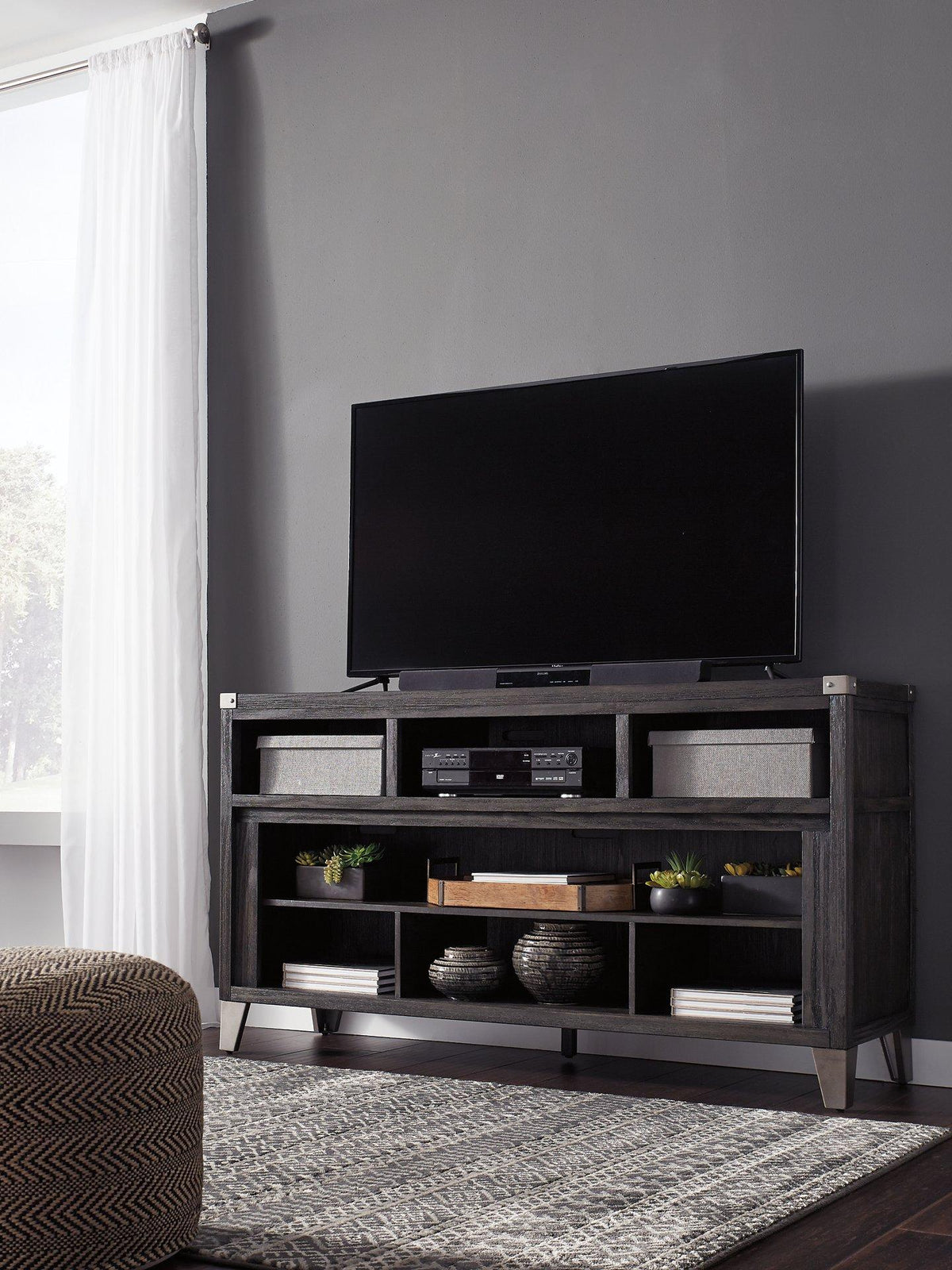 Ashley Furniture Todoe 65-inch TV stand with built-in electric fireplace, modern wood finish, and ample storage compartments.
