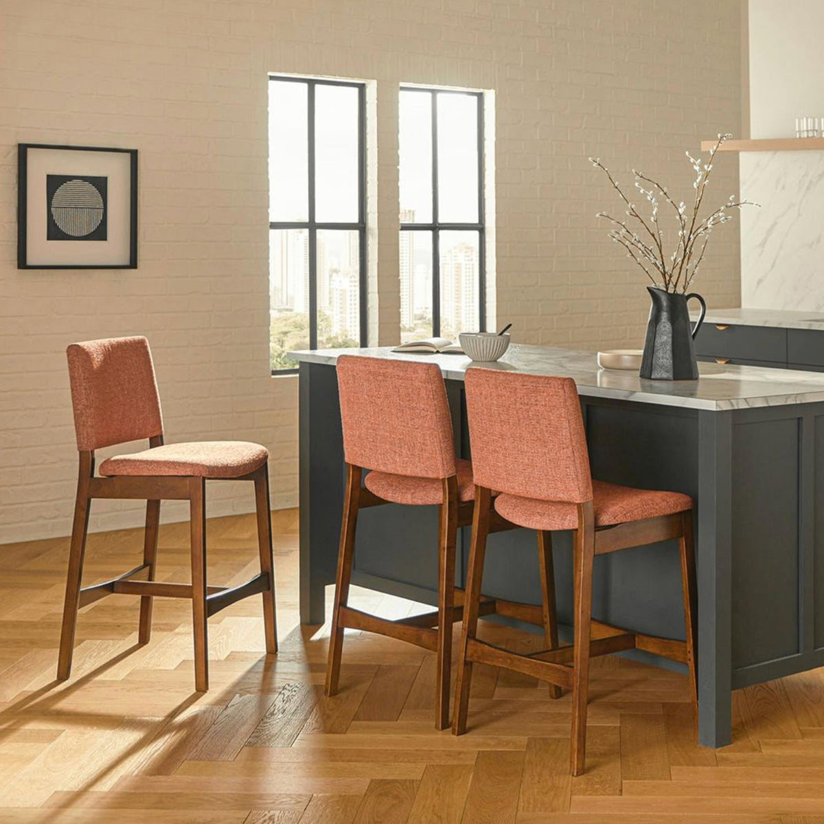 Orange upholstered MCM-style barstool by Article with walnut wooden legs, designed for counter seating.