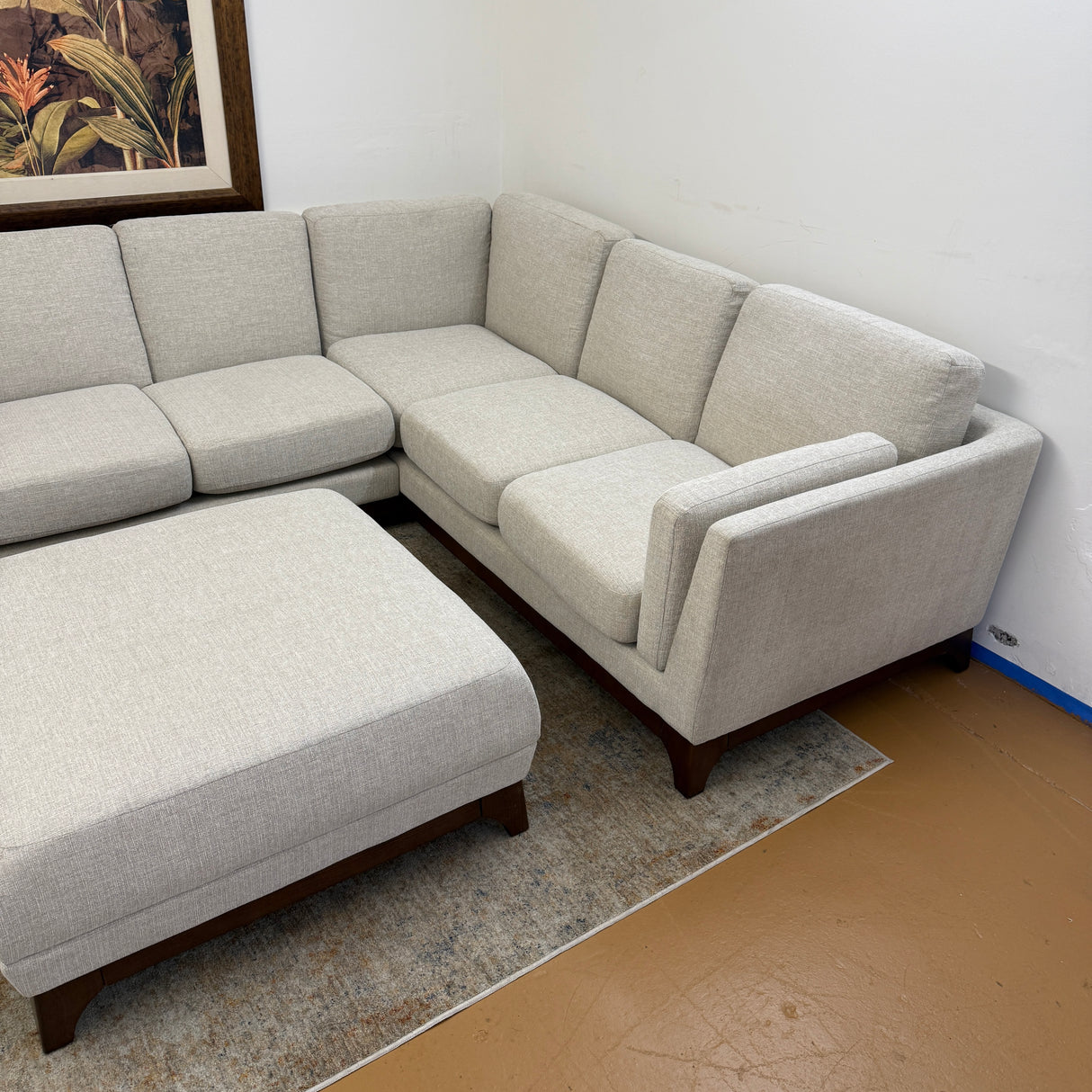 Chalk gray Article 88-inch corner sectional sofa with matching ottoman, featuring walnut accents and plush cushions.