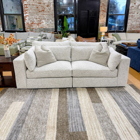 Ashley Furniture Alpine 2-piece sectional sofa with plush cushions and modern design, shown in a spacious living room setting.