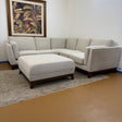 Chalk gray and walnut 88-inch sectional sofa with ottoman by Article, showing plush cushions and modern design in a living room setting.