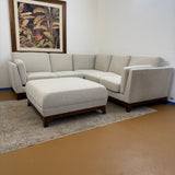 Chalk gray and walnut 88-inch sectional sofa with ottoman by Article, showing plush cushions and modern design in a living room setting.