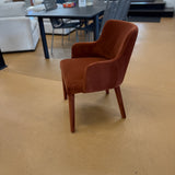 Rust velvet MCM-style armchair by Article with sleek wooden legs and curved armrests, showcasing modern retro design.