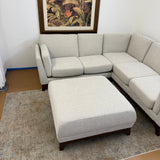 Chalk gray Article 88-inch corner sectional sofa with matching ottoman, modern design and walnut wood legs.