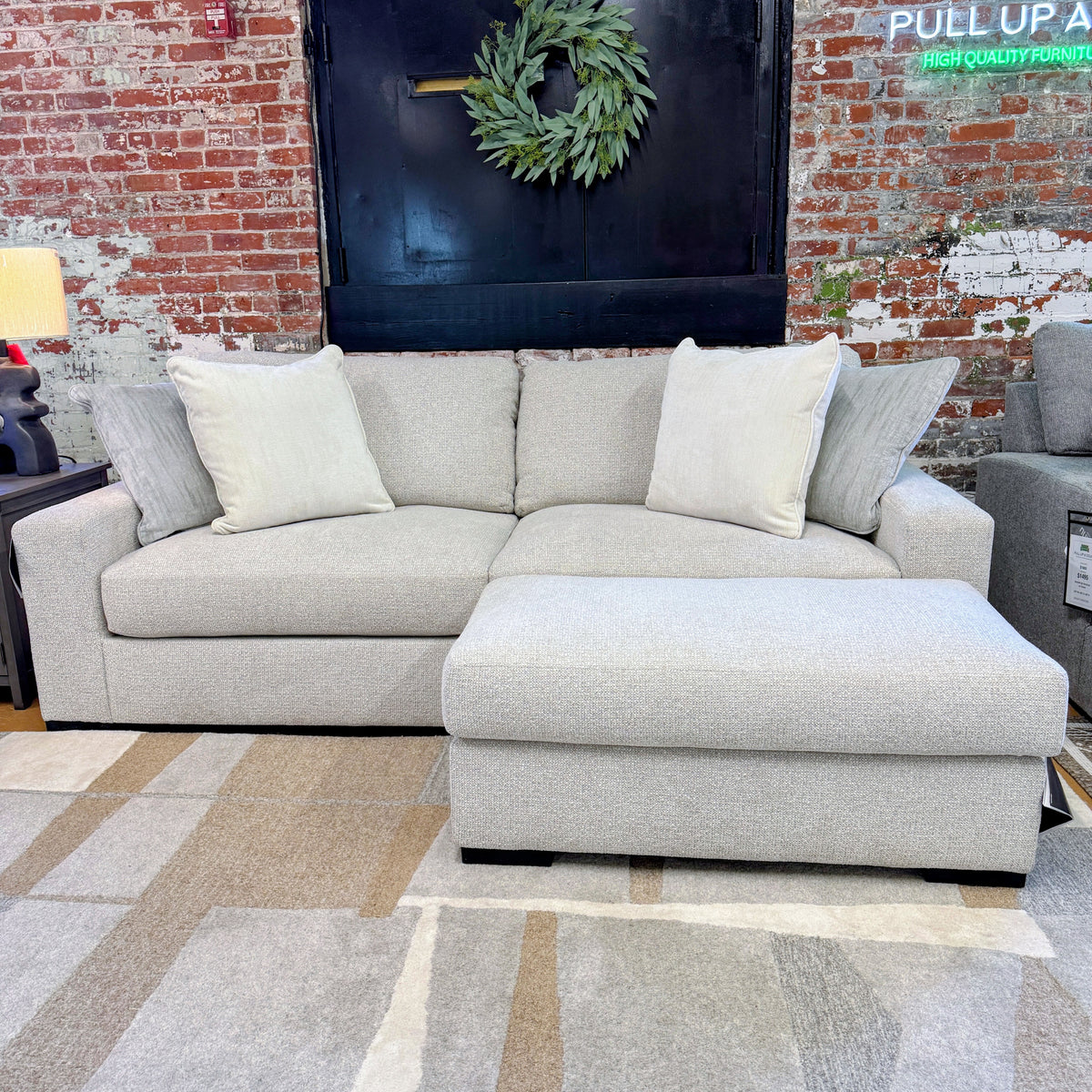 Ashley Furniture Hudson Sofa, plush fabric upholstery with tufted back and rolled arms, shown in a stylish living room setting.