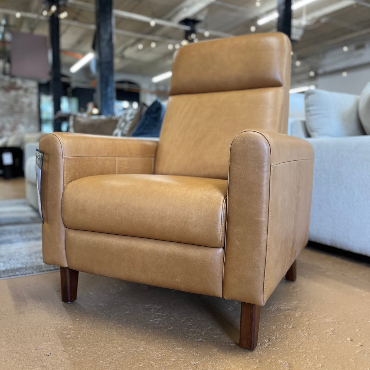 Article MCM recliner chair in Taos tan leather with plush cushioning and modern design, showcasing a comfortable seating option.