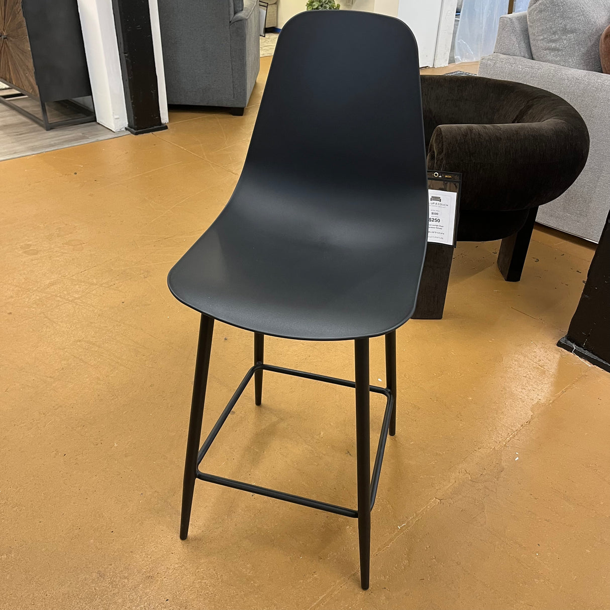 Black MCM barstool by Article featuring a sleek, modern counter-height design with a sturdy frame and comfortable seating.