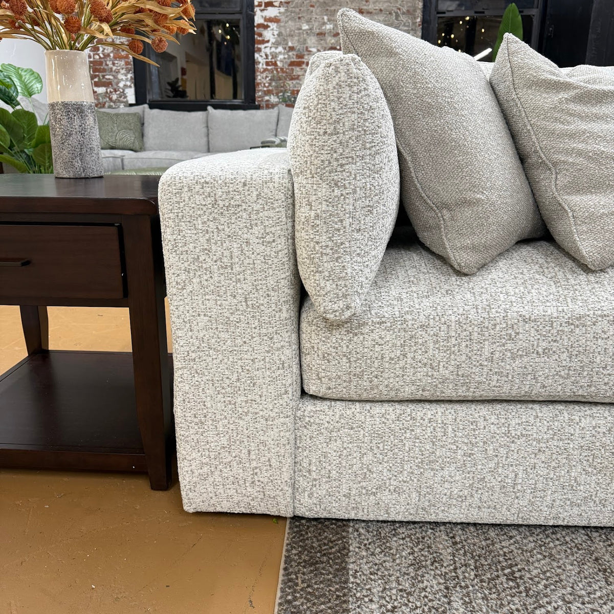 Ashley Furniture Alpine 2-piece sectional sofa arm with beige upholstery and plush cushioning, showing detailed fabric texture.