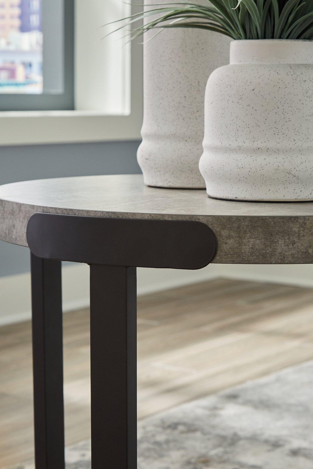 Set of three Ashley Furniture Darthurst tables with dark wood finishes, featuring sleek round tabletops and sturdy legs.